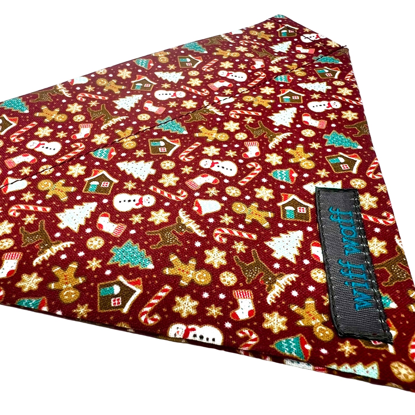 Christmas-themed fabric with gingerbread men, candy canes, and snowmen on a red background.