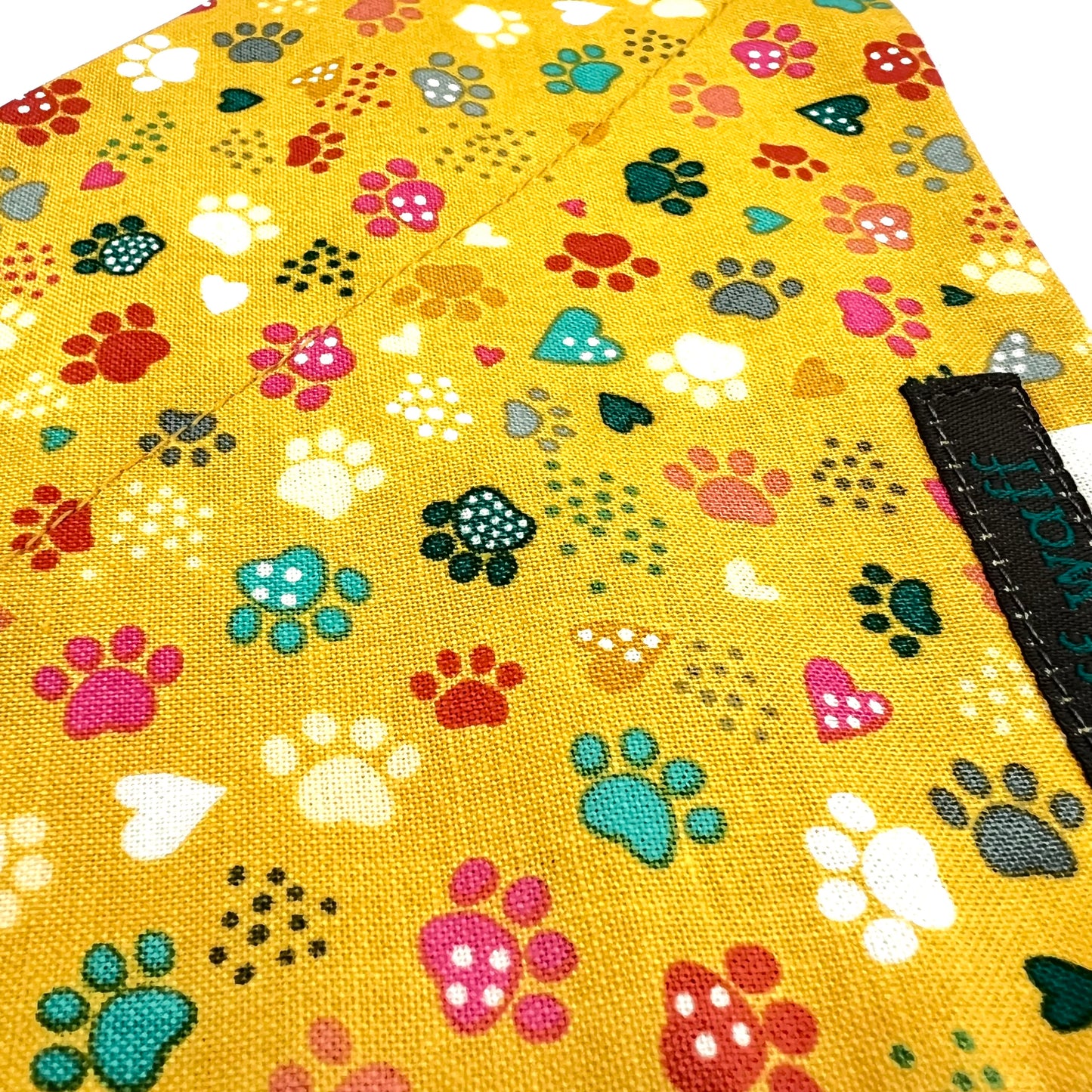 Yellow fabric with colourful paw prints and heart shapes