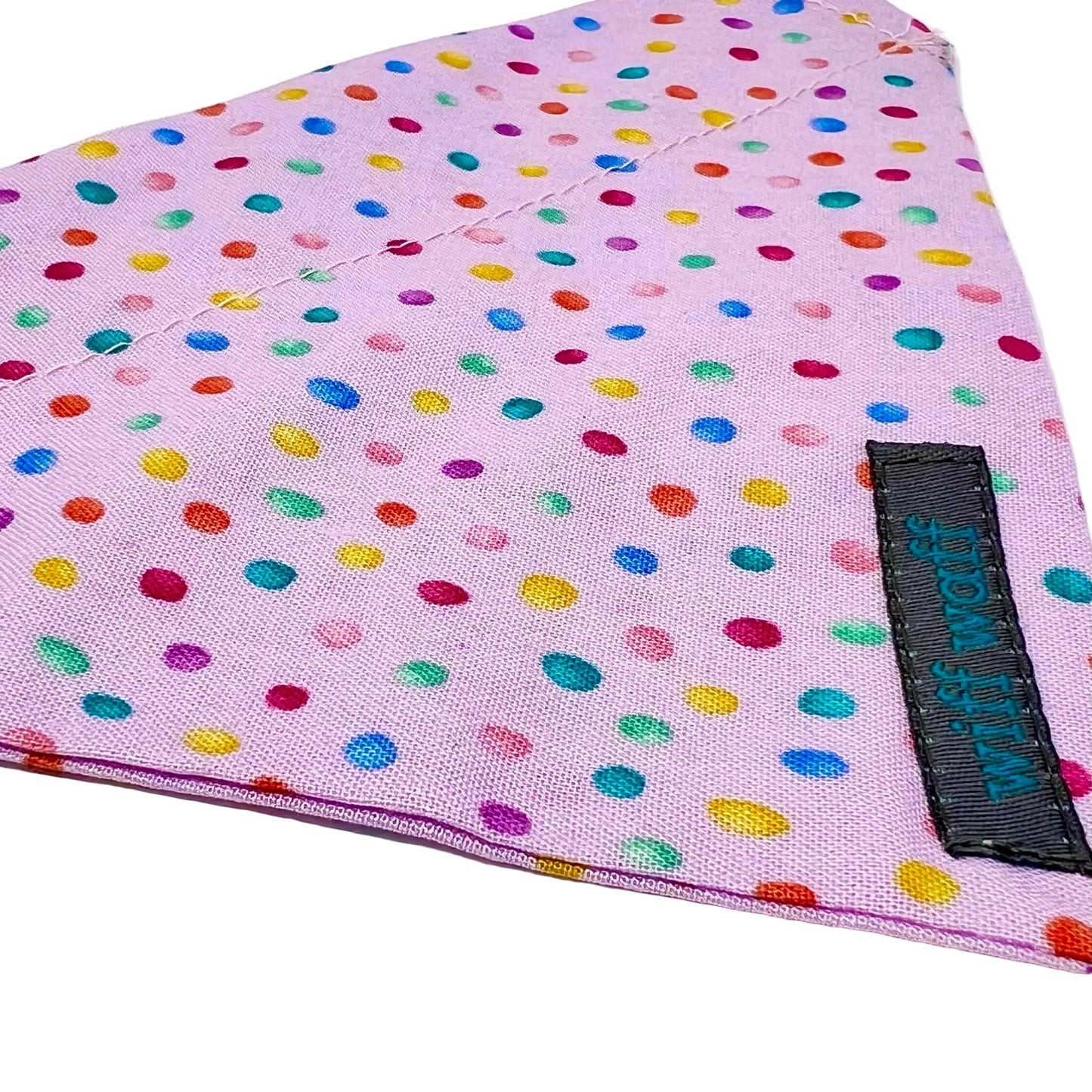 a dog bandana which has a pink back ground with tiny colourful rainbow bubbles scattered across it.