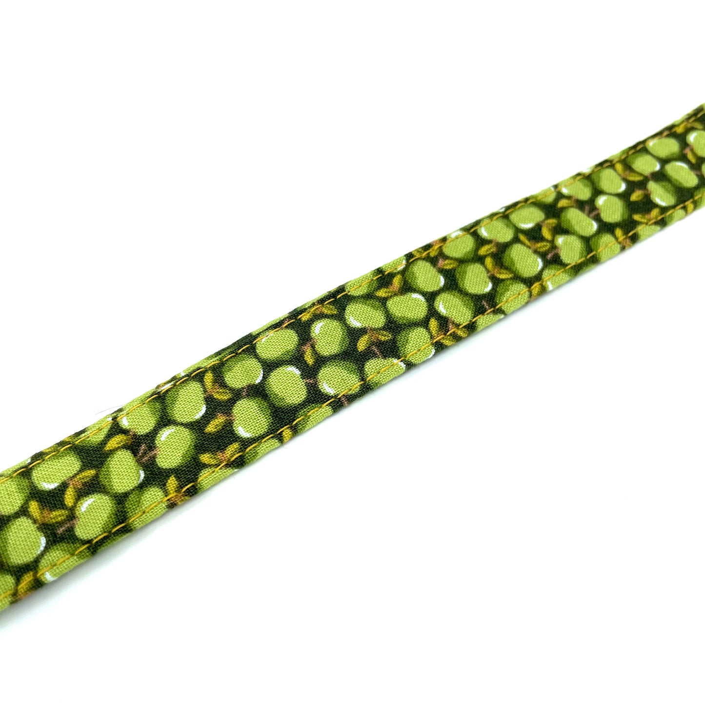 close up image of a green apple print dog lead with pale green stitching. Handcrafted by wiff waff designs in Nottingham