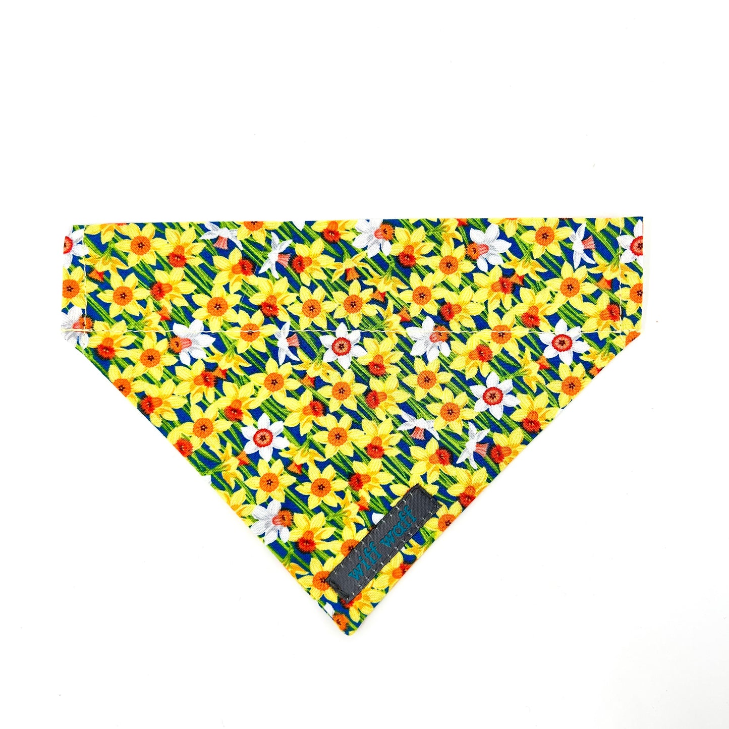 Yellow and white floral daffodil patterned dog bandana with a visible brand tag on a blue background