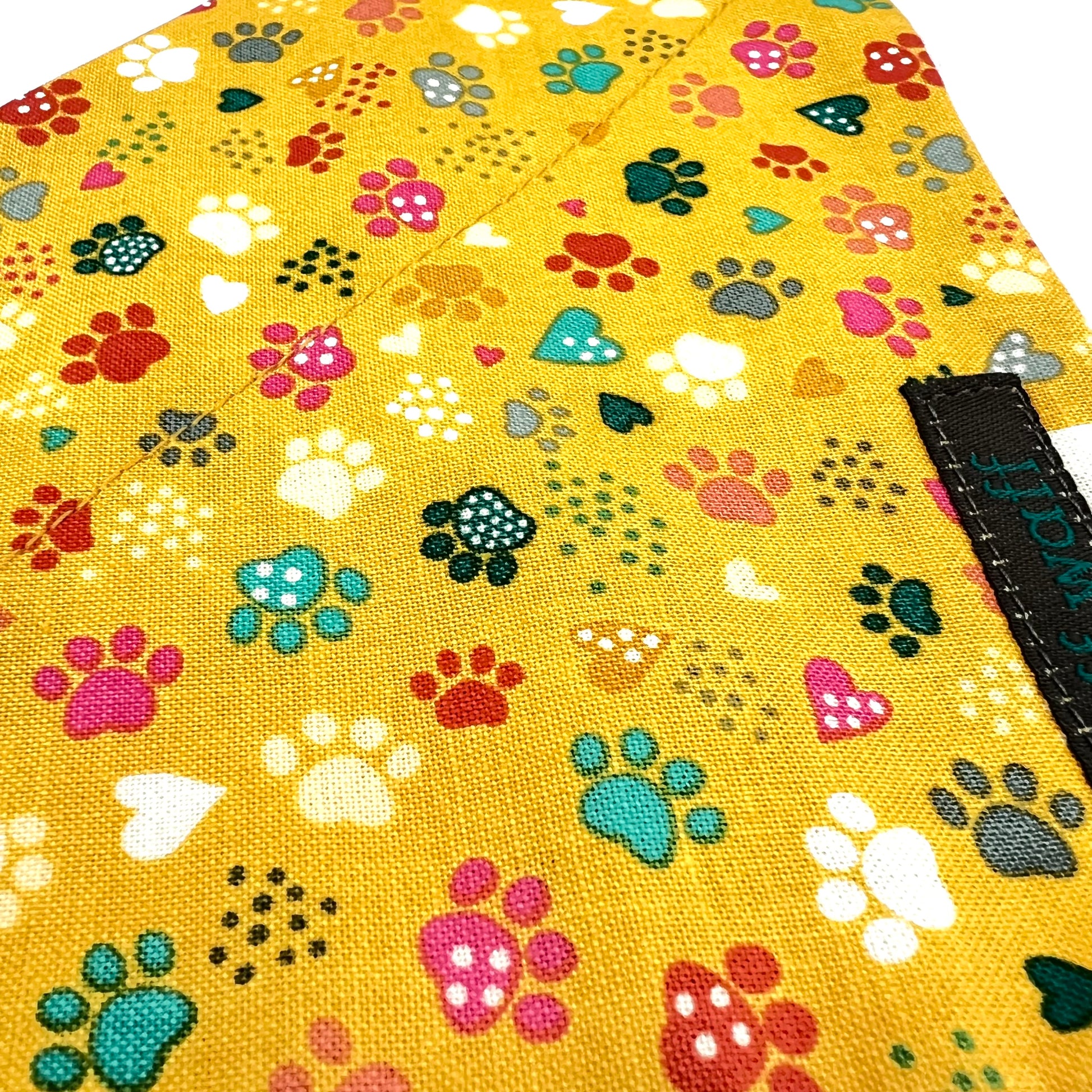 Yellow fabric with colourful paw prints and heart shapes