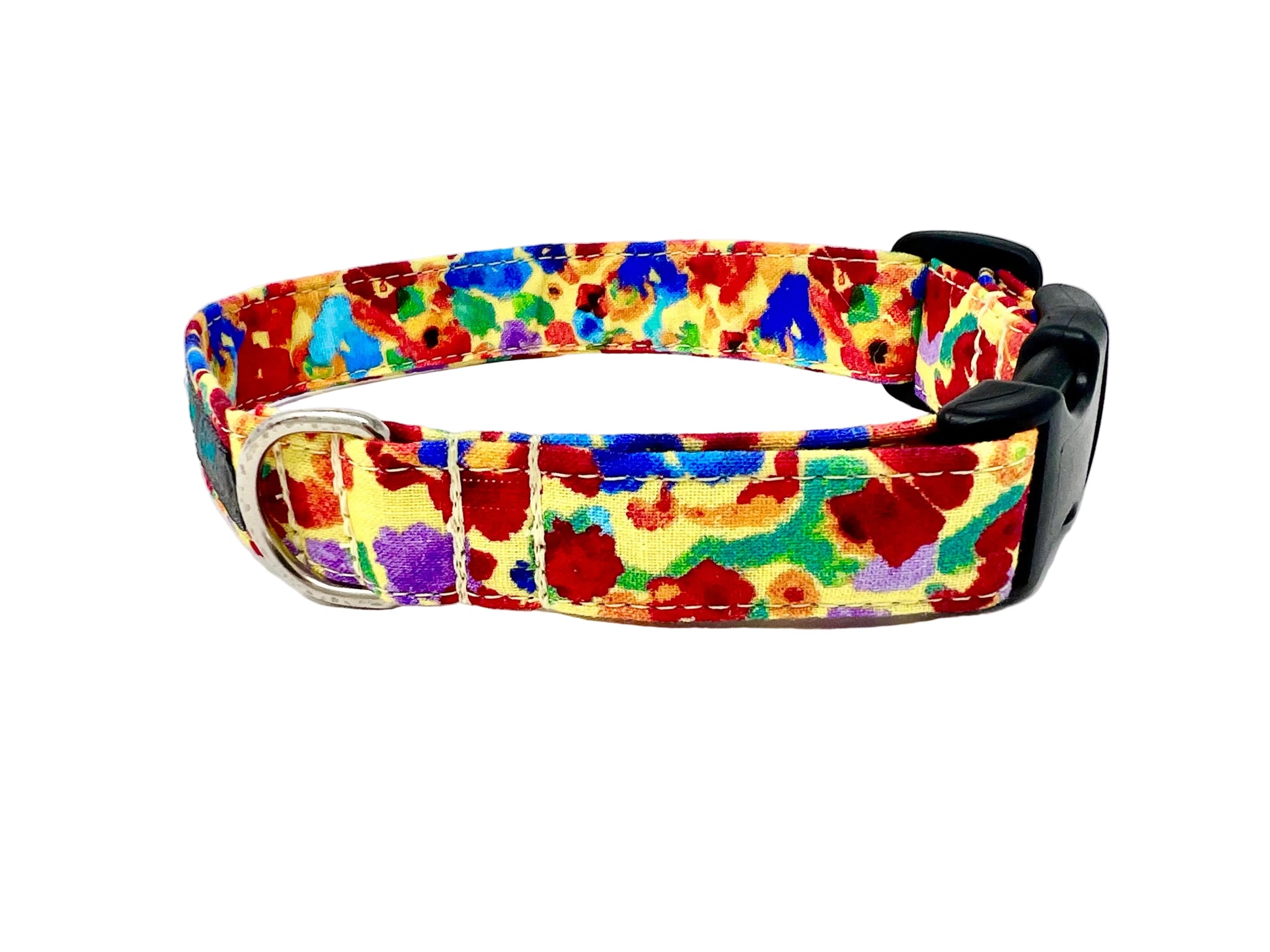 Colourful dog collar set against a light yellow background adorned with irregular, abstract blotches in red, blue, green, purple, and occasional orange. 