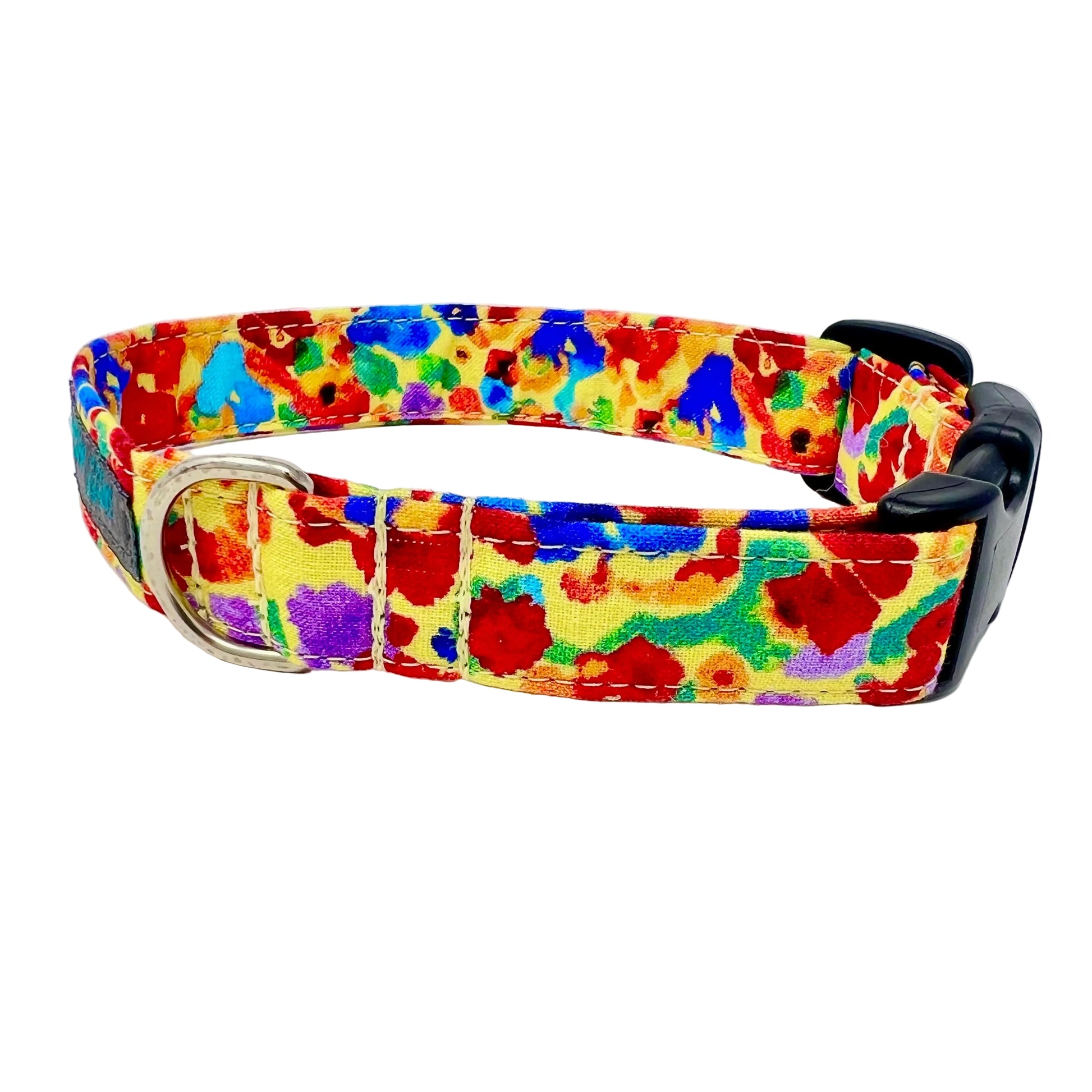 Colourful dog collar set against a light yellow background adorned with irregular, abstract blotches in red, blue, green, purple, and occasional orange. 