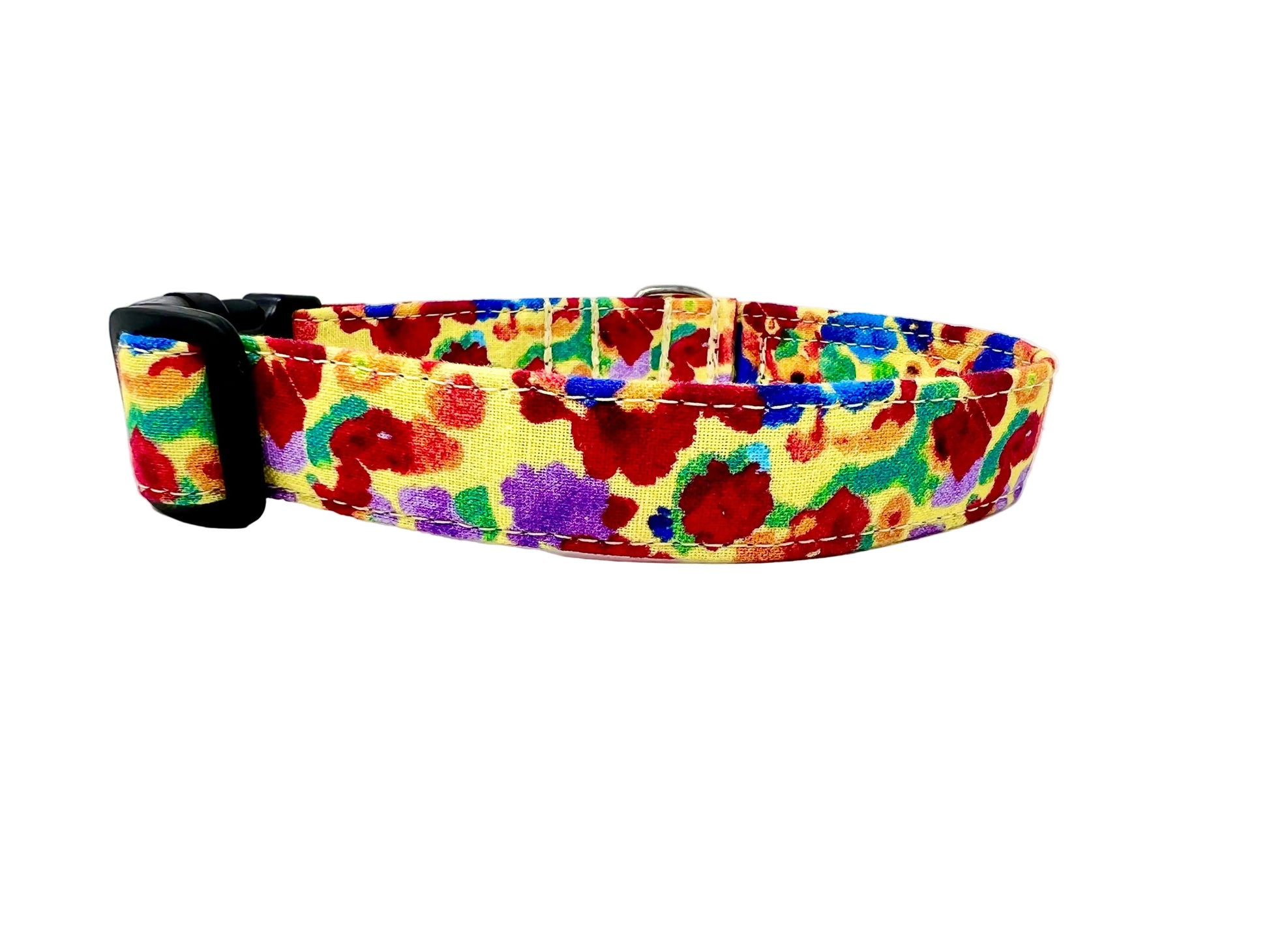 Colourful dog collar set against a light yellow background adorned with irregular, abstract blotches in red, blue, green, purple, and occasional orange. 