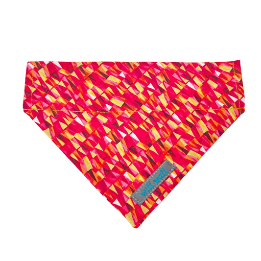 A dog collar bandana featuring pink and red hues accented with gold metallic touches