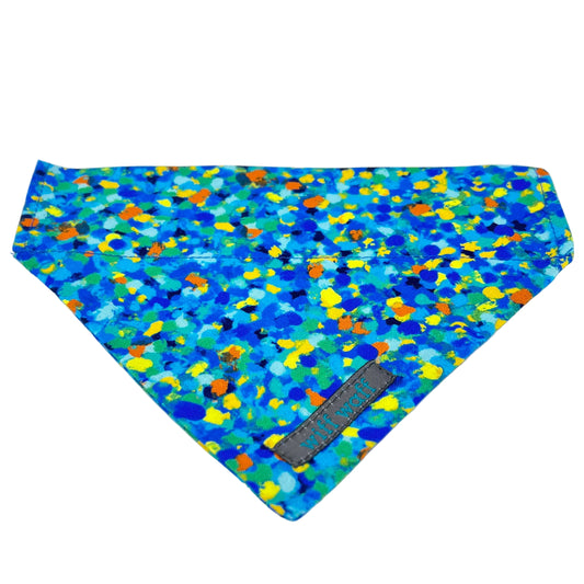 Celeste Blue dog bandana has the appearance of paint splatters composed of various blue tones, complemented by subtle accents of yellow, orange, and green. 
