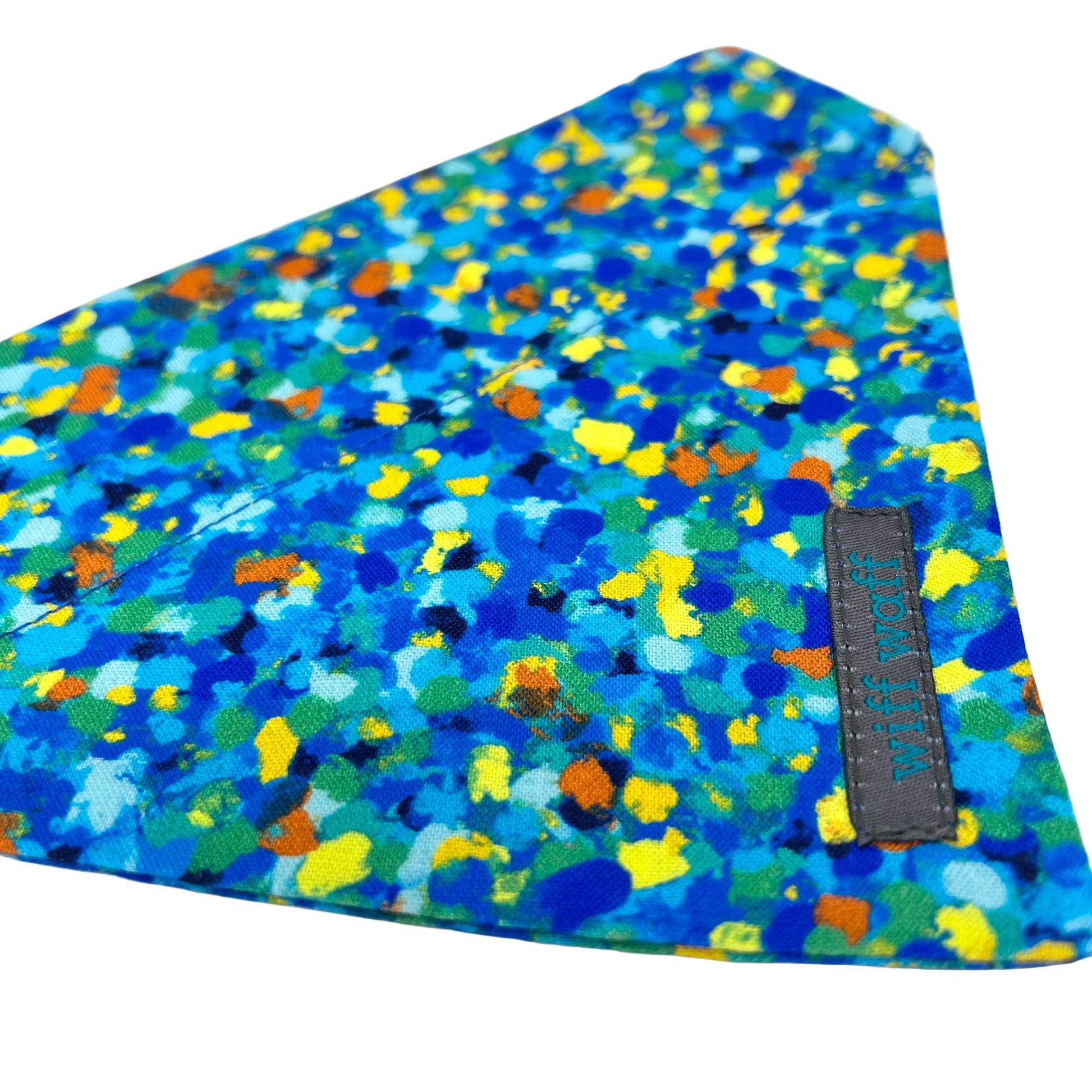 Celeste Blue dog bandana has the appearance of paint splatters composed of various blue tones, complemented by subtle accents of yellow, orange, and green. 