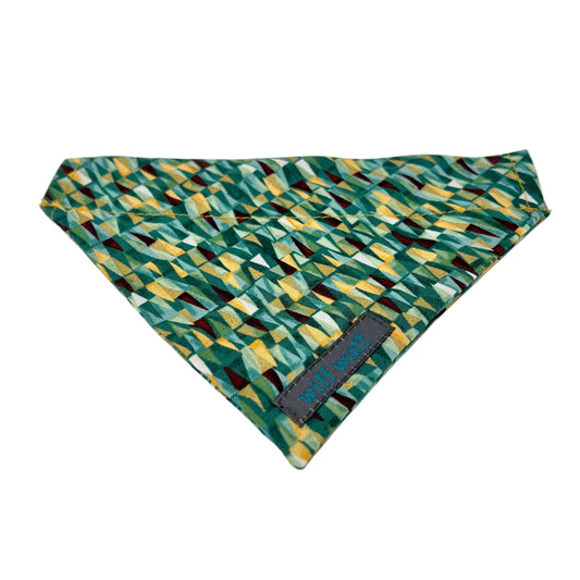 a dog collar bandana in fabric iwith shades of greens and has gold metallic highlights.