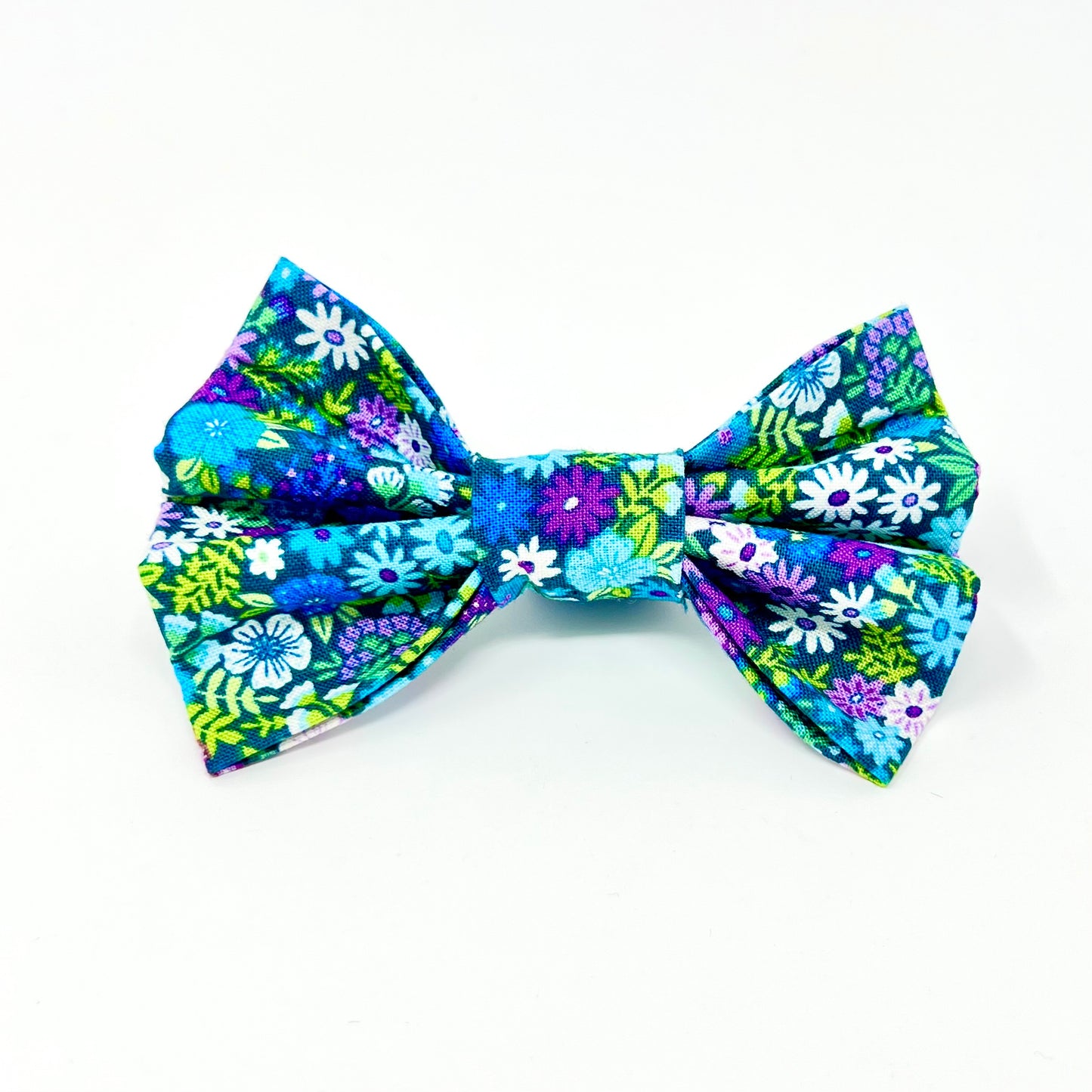 colourful dog bow featuring a vibrant floral design in shades of blue, violet, green and white