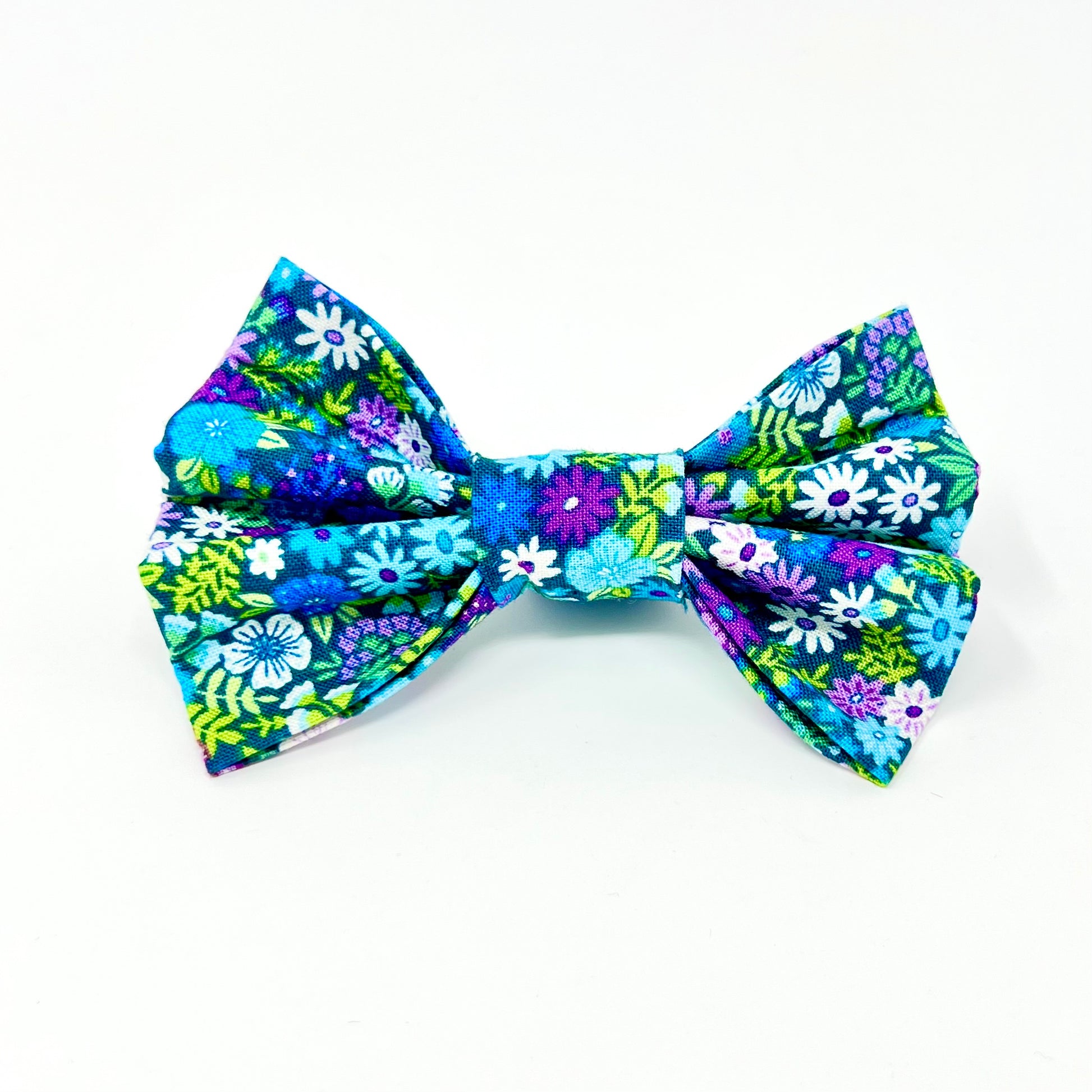 colourful dog bow featuring a vibrant floral design in shades of blue, violet, green and white