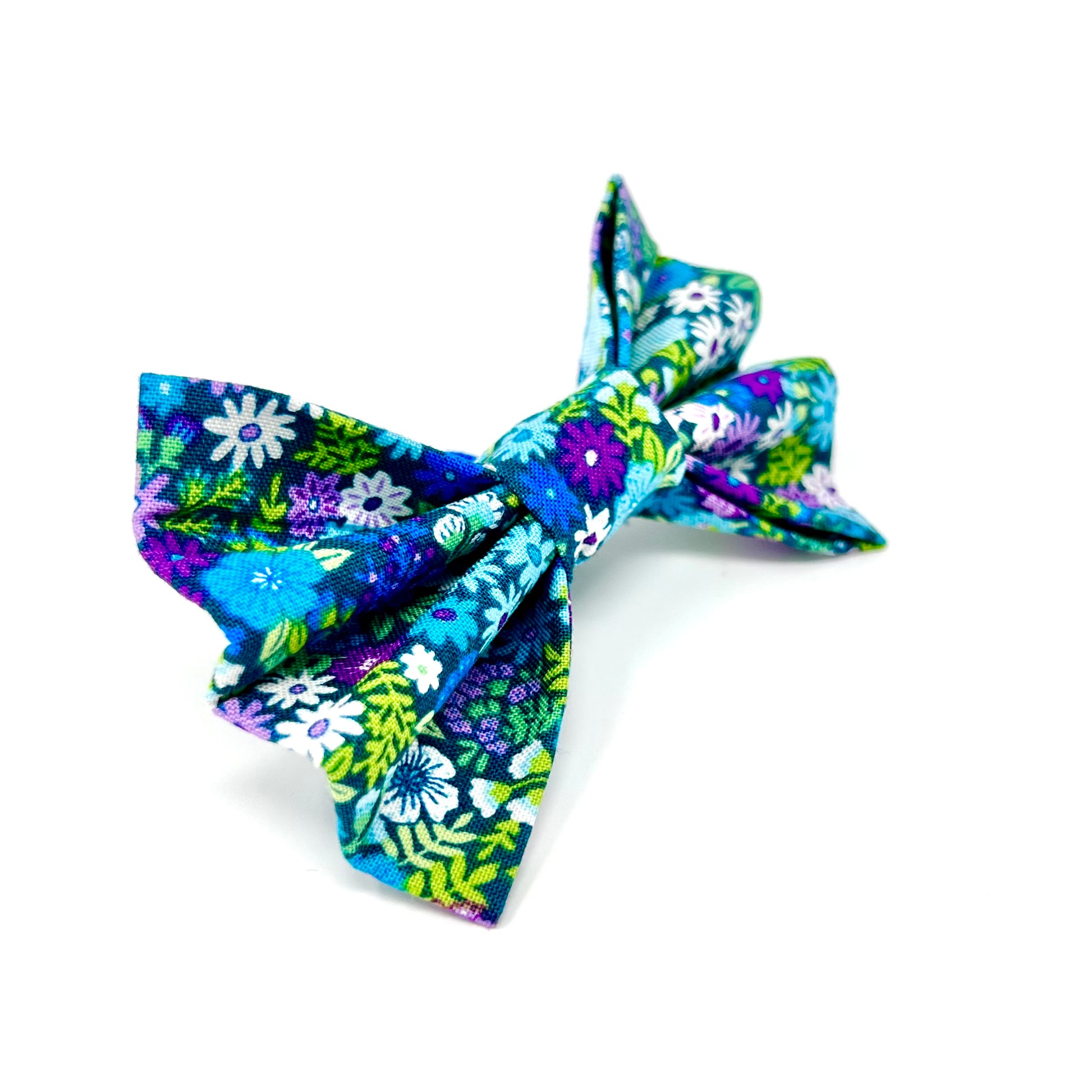 colourful dog bow featuring a vibrant floral design in shades of blue, violet, green and white