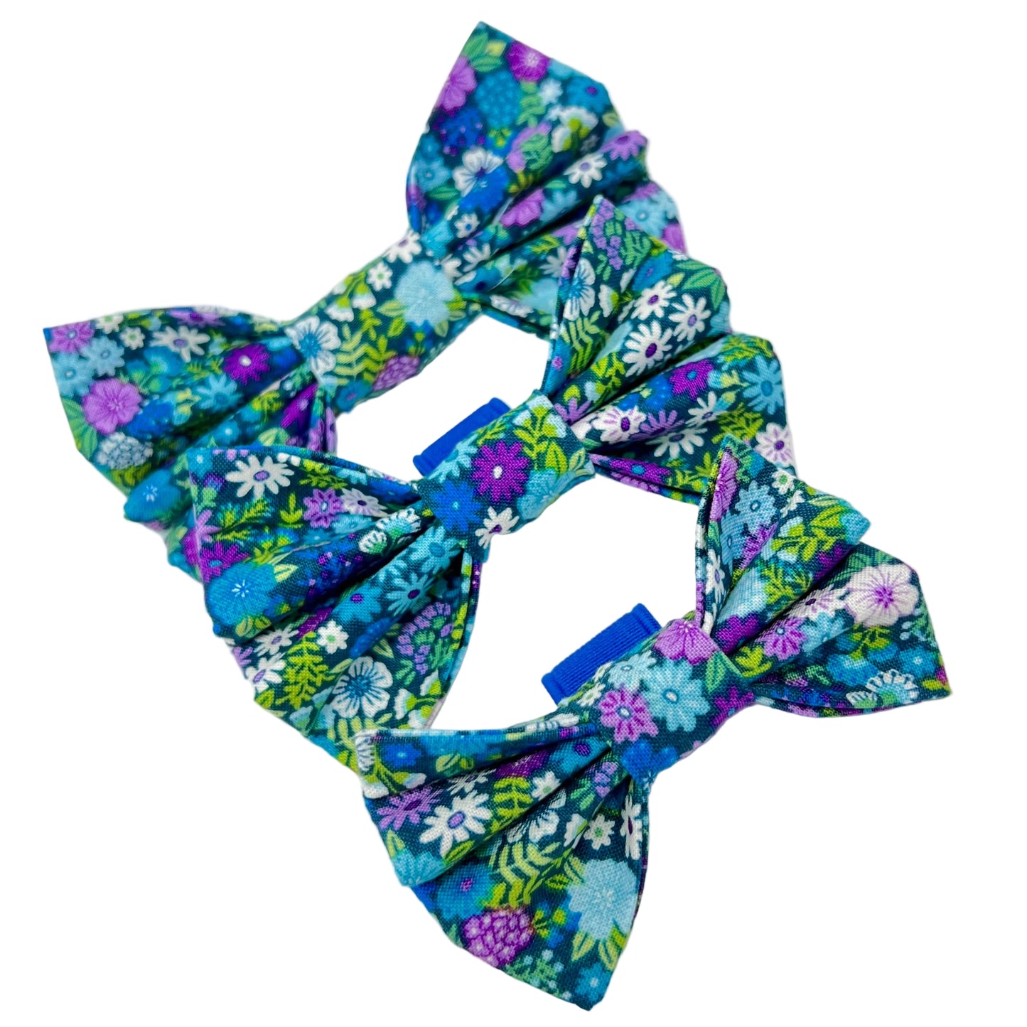 colourful dog bows featuring a vibrant floral design in shades of blue, violet, green and white. sizes small, medium and large.