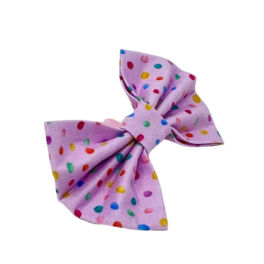 dog bow with  a pink back ground and tiny colourful rainbow bubbles scattered across it. feminine 
