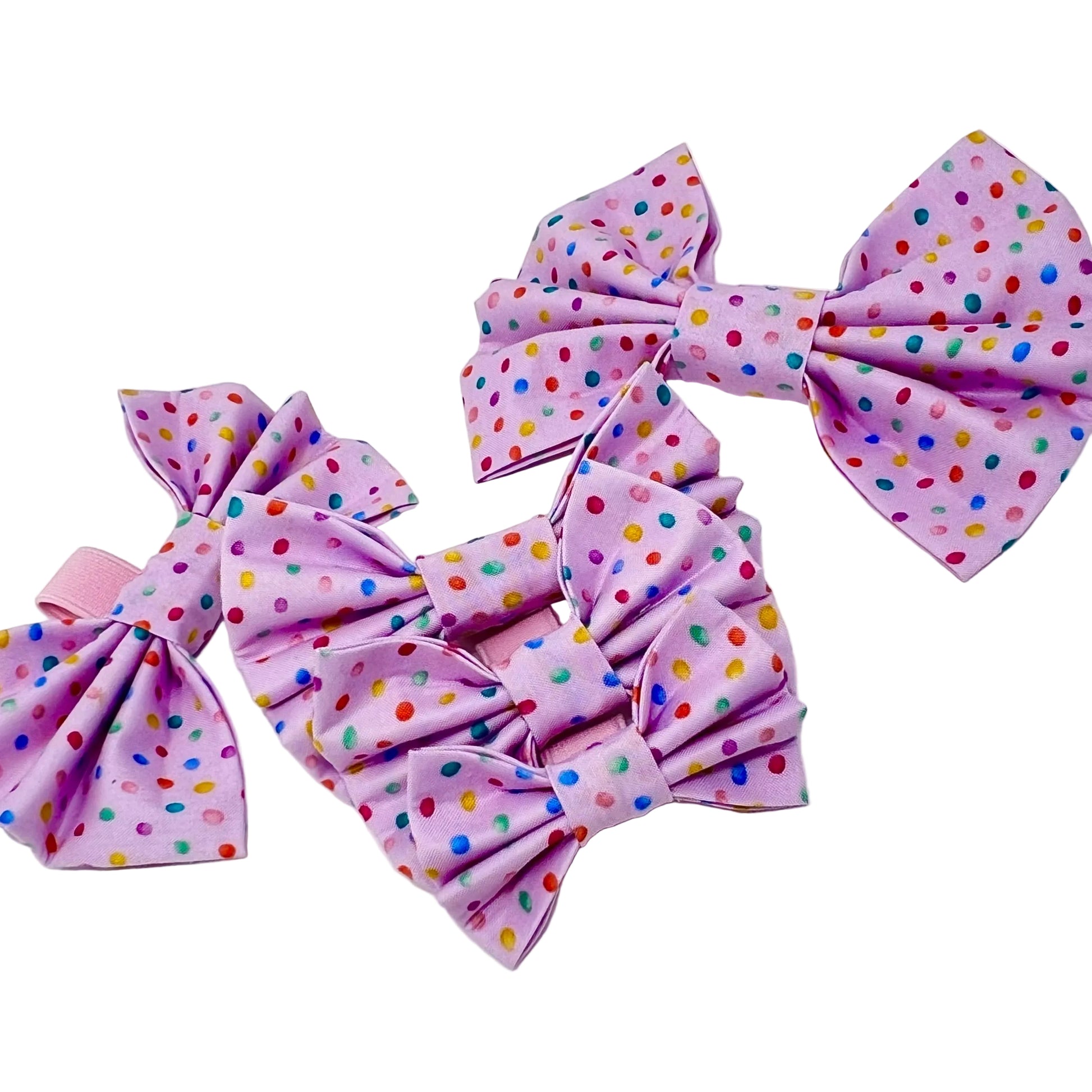 five dog bows. Fabric has a pink back ground and tiny colourful rainbow bubbles scattered across it. feminine . Sizes small, medium, large, small XL and XL