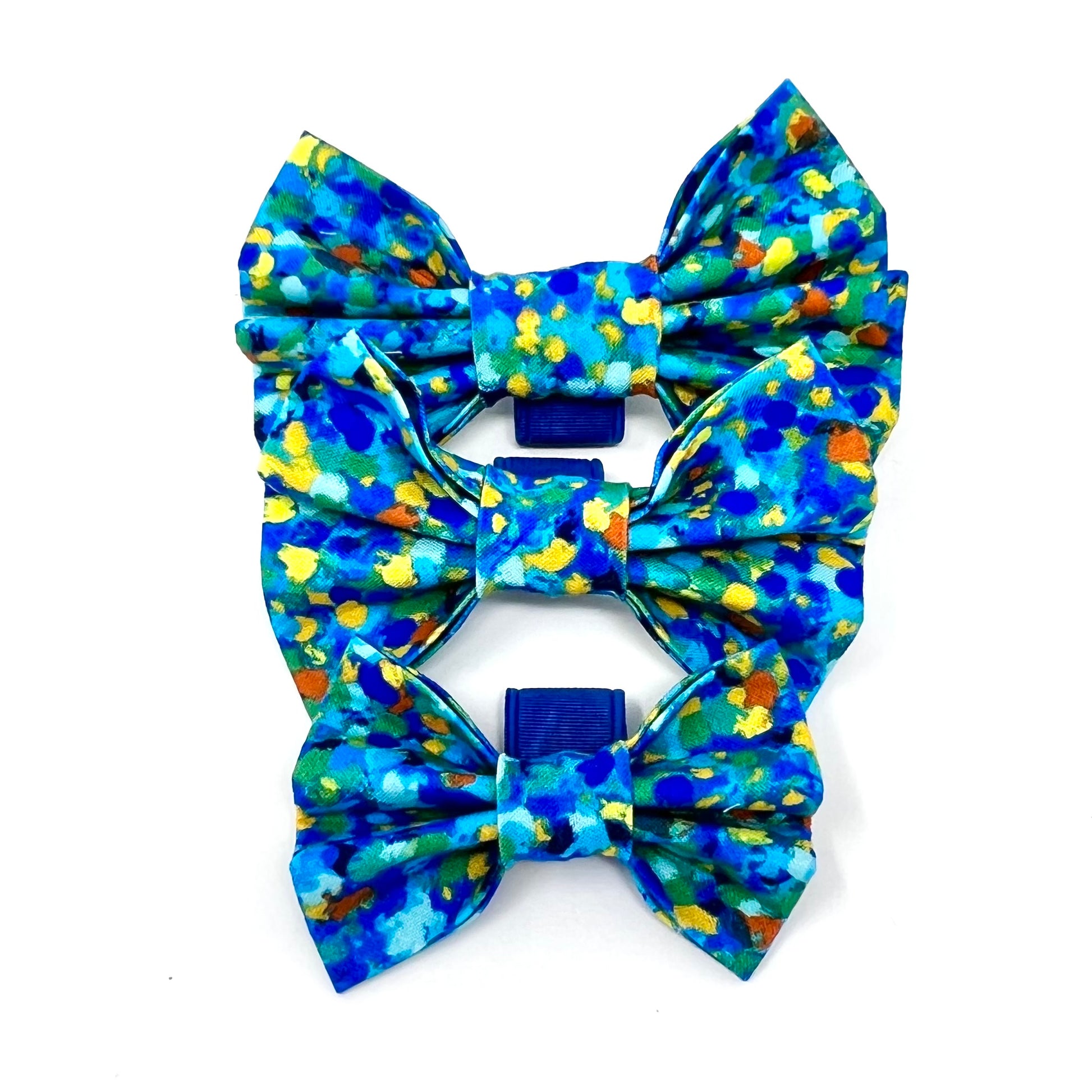 Small, medium and large bow tie composed of various blue tones, complemented by subtle accents of yellow, orange, and green.