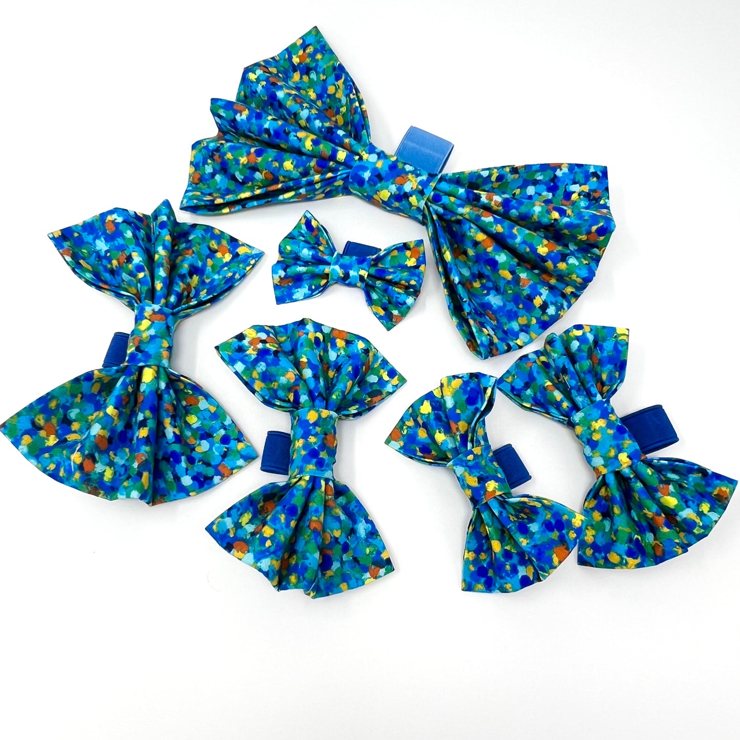 six sizes of bow ties composed of various blue tones, complemented by subtle accents of yellow, orange, and green.Range from small to XL to suit any sized dog or cat