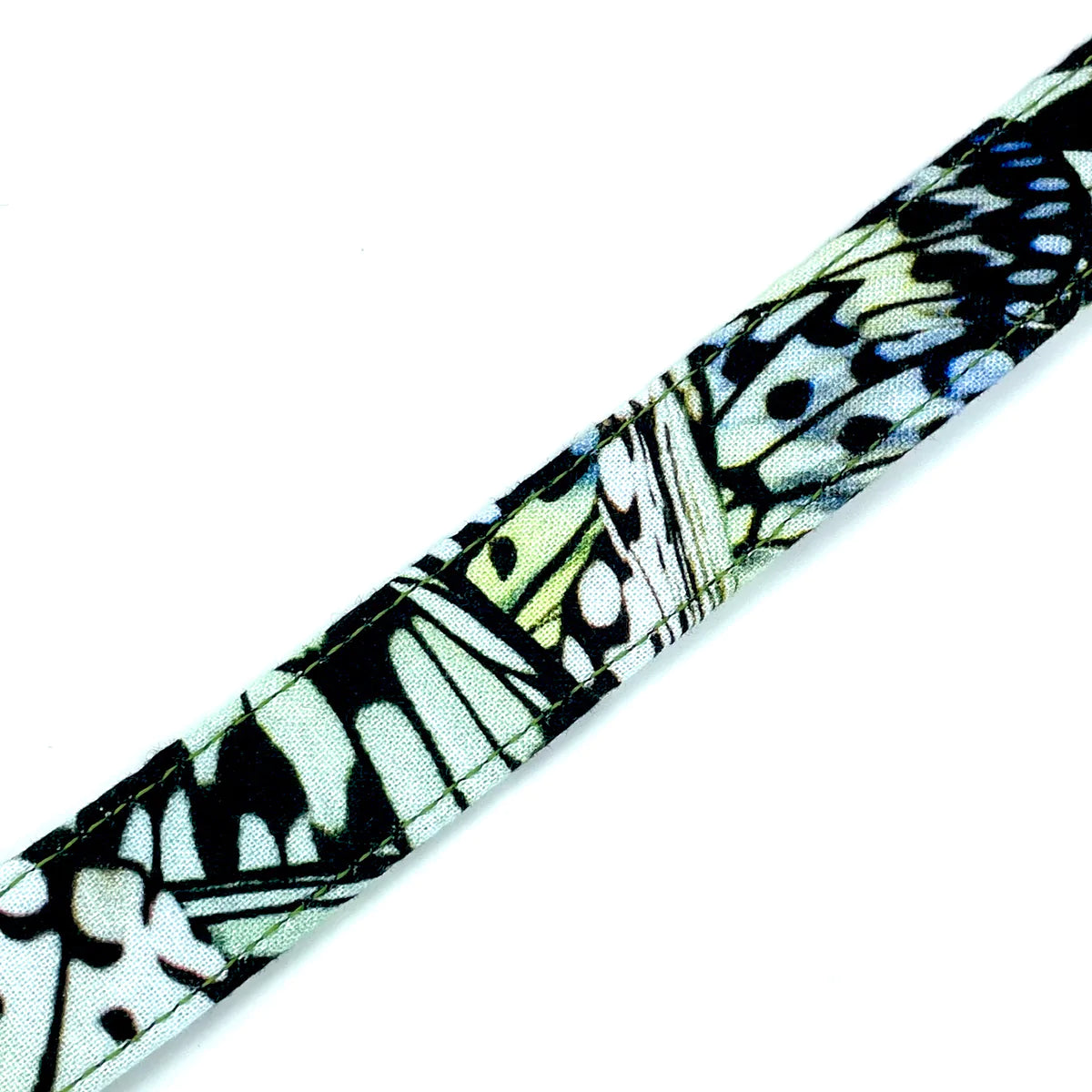 Close up image of a handcrafted dog collar by wiff waff designs with green and black butterfly wing print.